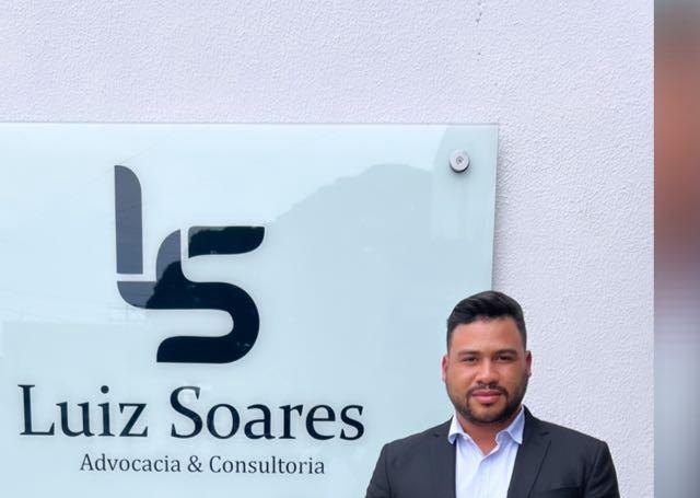 Luiz Soares em frente à placa do escritório Luiz Soares Advocacia